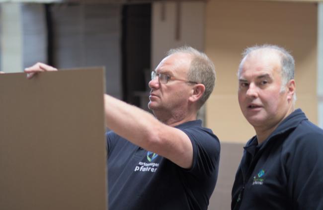 Deux employés étudiant une surface de carton.